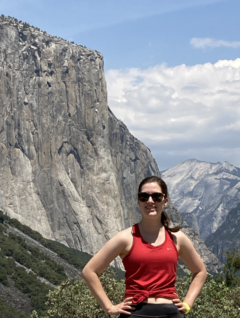 A woman standing in front of mountains at Yosemite National Park.